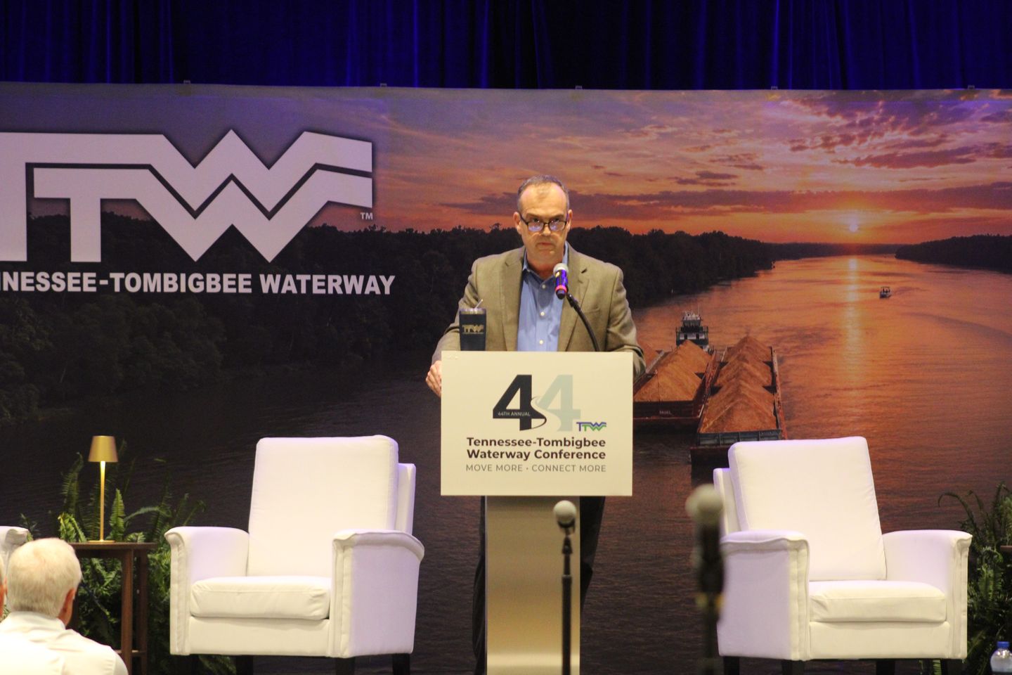 A speaker addresses the conference from the main stage podium.