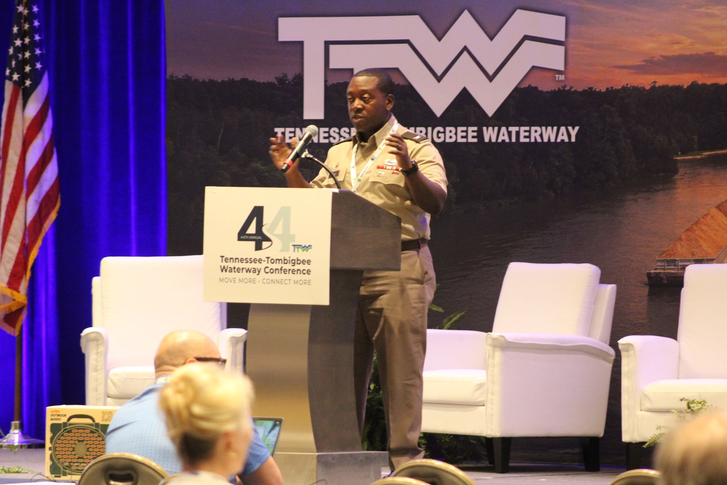 An Army officer speaks from the main stage podium.