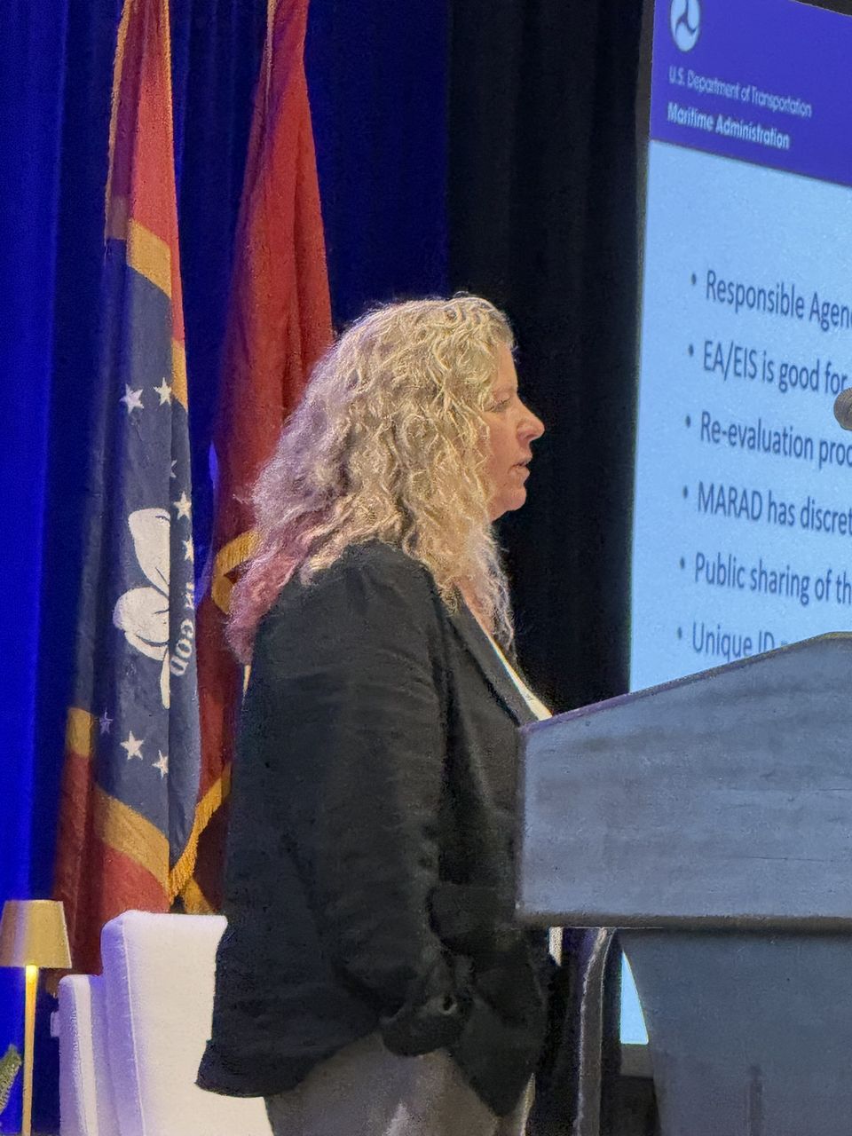A speaker presenting beside slides from the U.S. Maritime Administration.