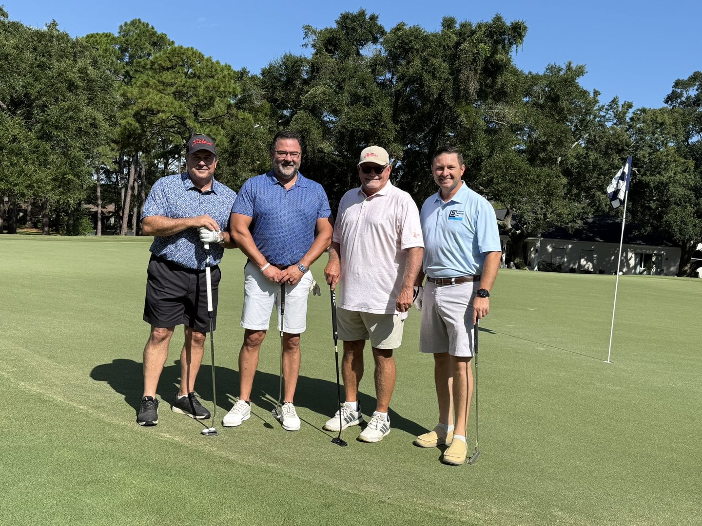 A golf foursome on the green.