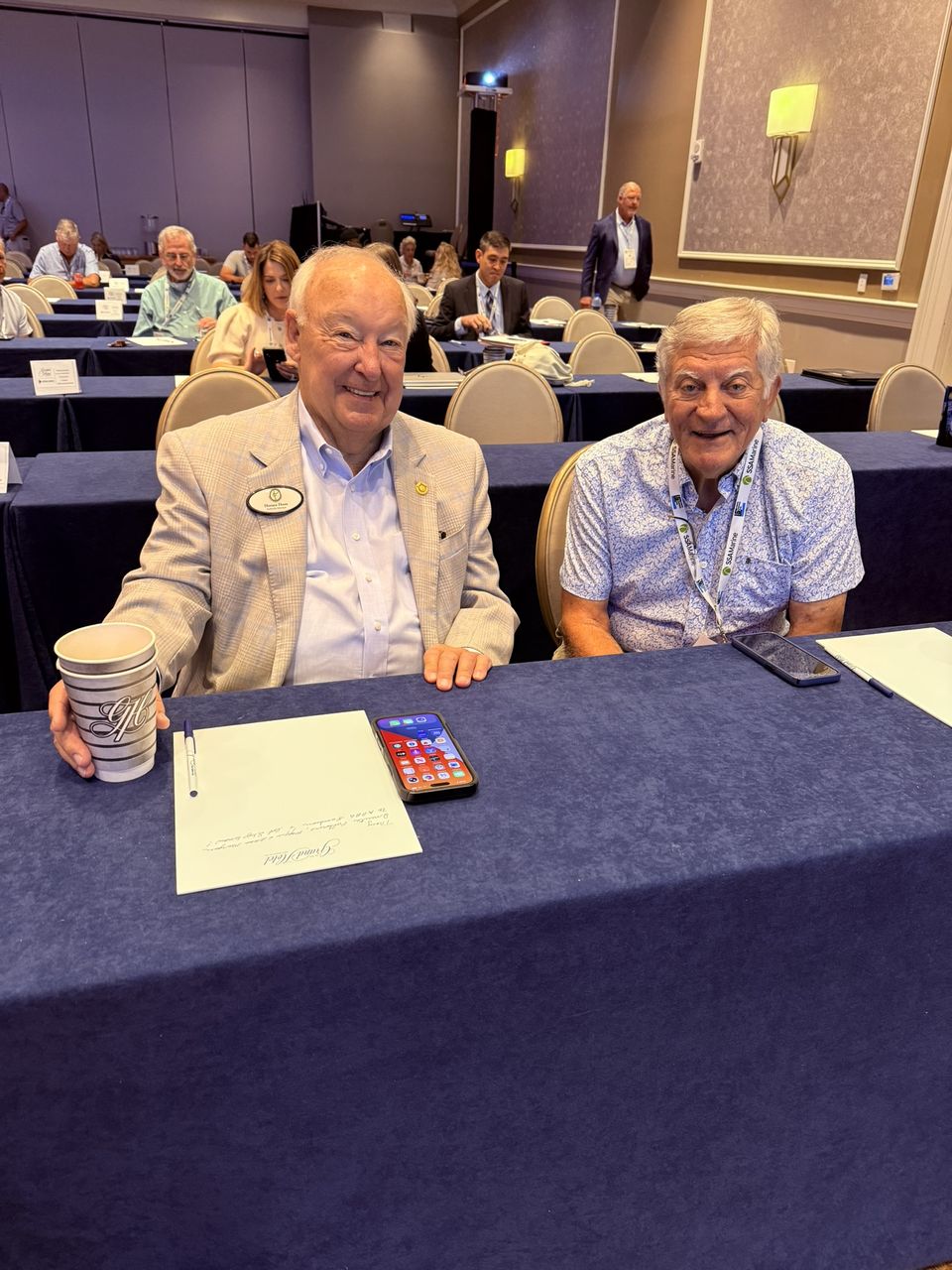 Two attendees seated at a session table.