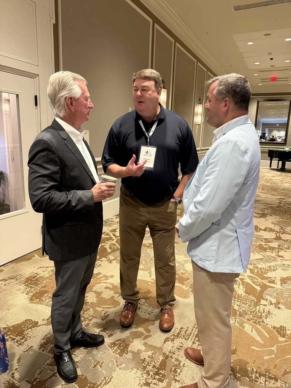 Three attendees in conversation.