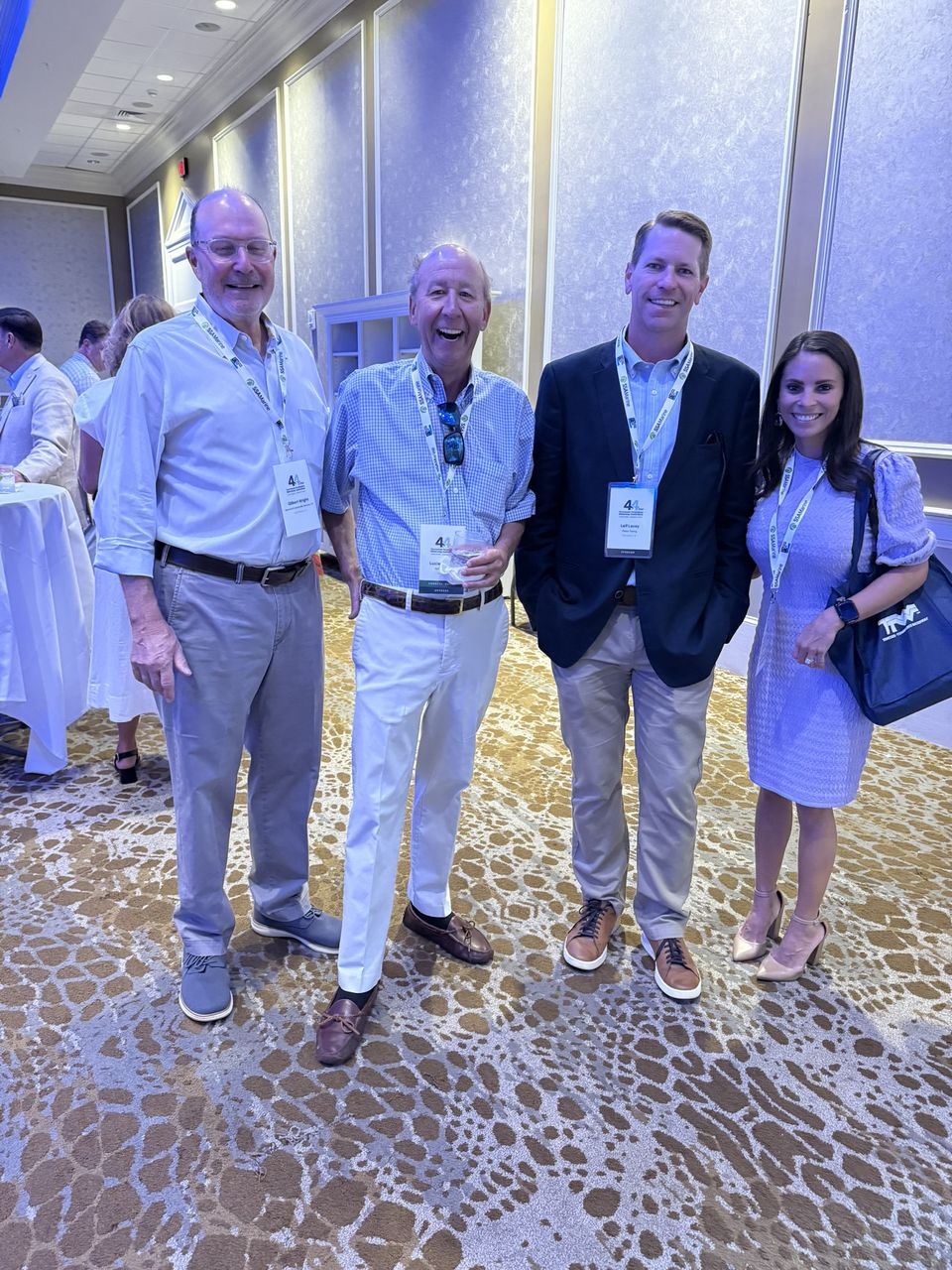 Four attendees pose in the ballroom foyer.