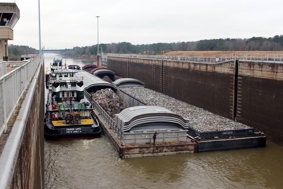 Towboats and barges secured side by side inside a Tenn-Tom lock chamber.