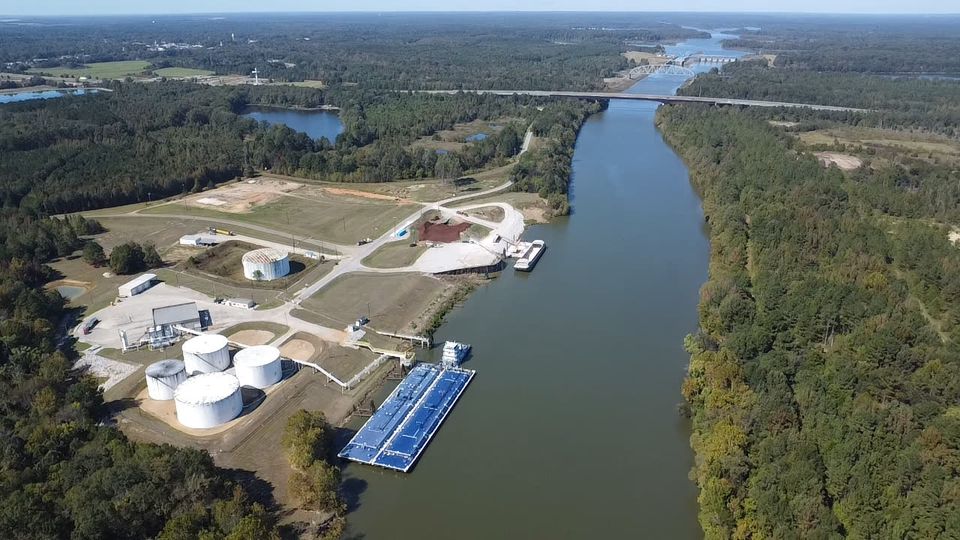 Aerial view of a port tank farm and dock on the waterway.