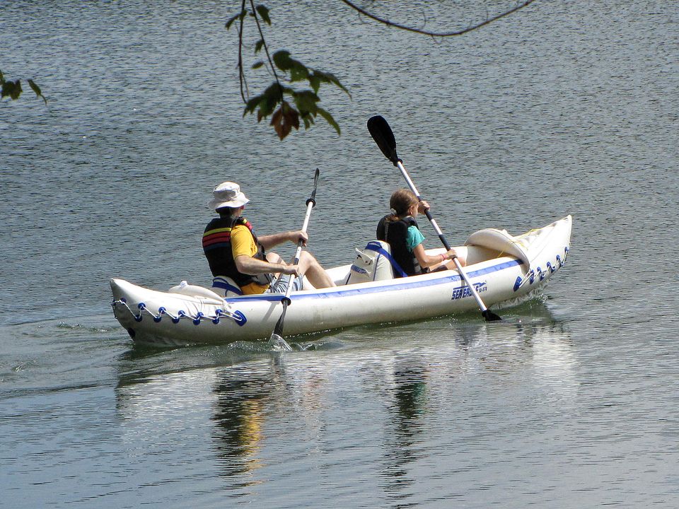 Two paddlers in a tandem kayak on a calm lake