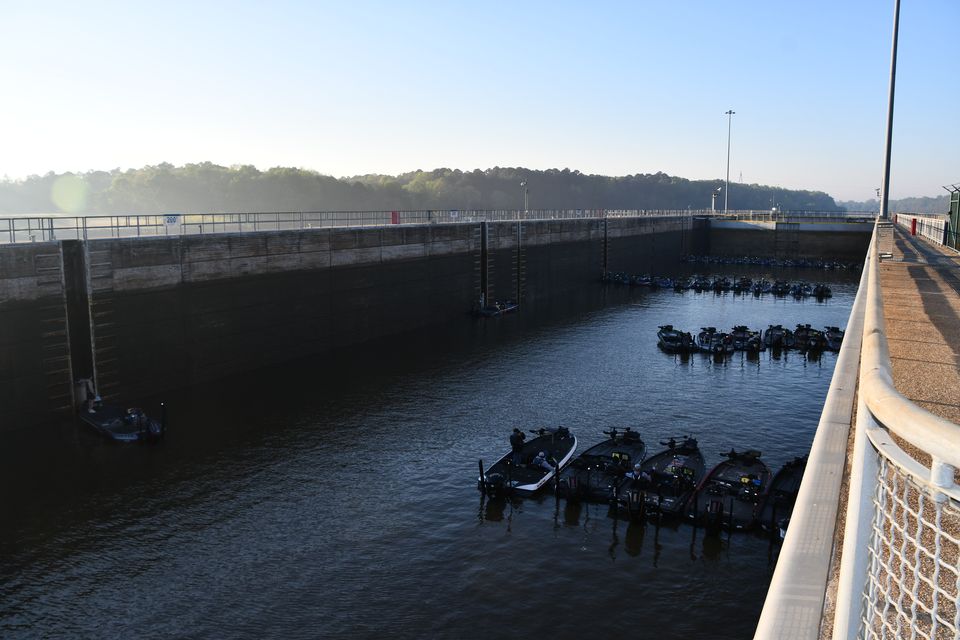 Bass boats locking through together, waiting in a lock chamber on a clear morning