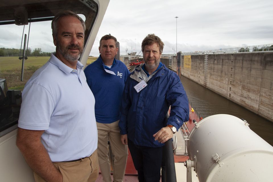 Three visitors aboard a boat in a lock chamber during a 2023 corridor tour