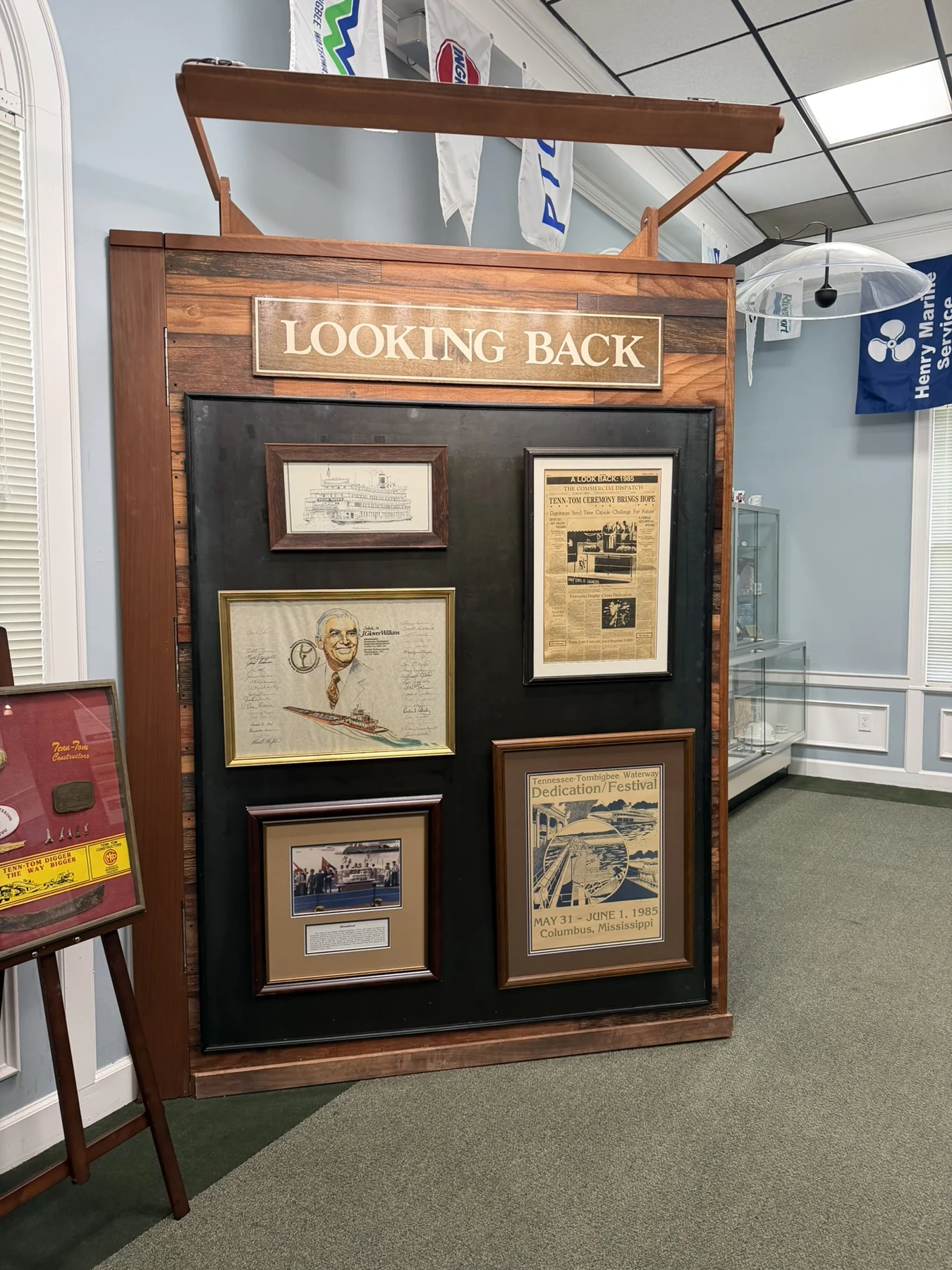 The Looking Back exhibit with archival photographs, a dedication festival poster and newspaper coverage