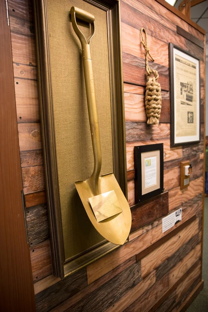 Golden groundbreaking shovel displayed alongside historical museum records